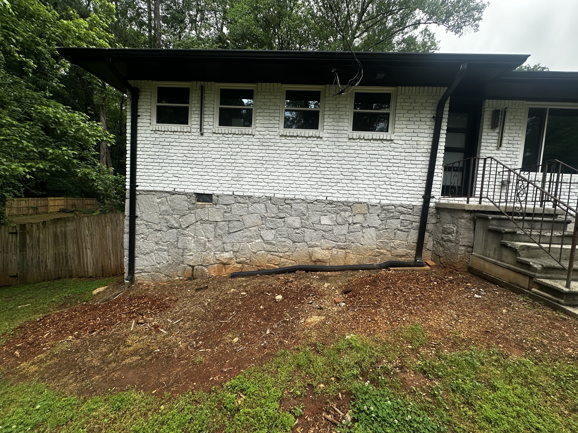 Bare dirt along stone foundation wall