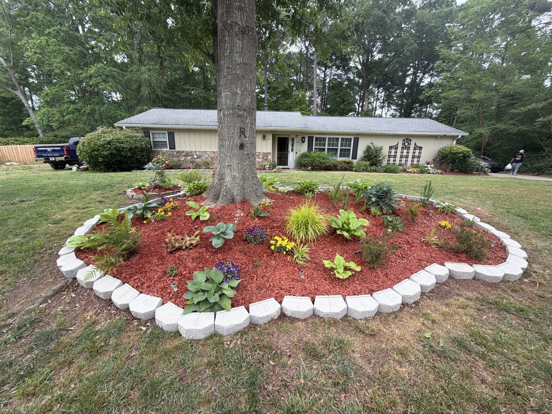 Stone border with colorful flowers and red mulch